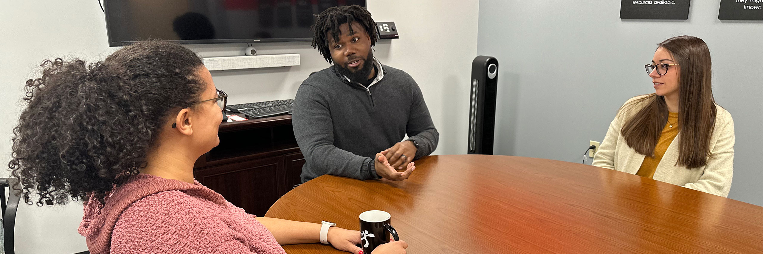 Staff talking in a meeting room.