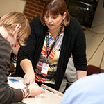 Adult students working together at a table.